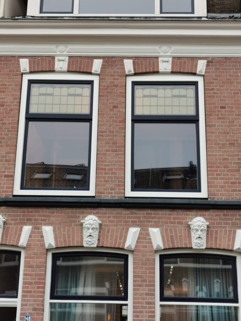 Een kunststof kozijn in een imitatie schuifraam. Gecombineerd met glas in lood om de oude originele stijl te benaderen