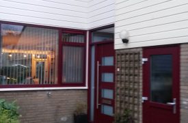 Voorgevel met kunststof gevelbekleding en raamkozijnen met moderne kunststof voordeur