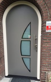 Kunststof voordeurkozijn met vleugeloverdekkend sierpaneel in een toog