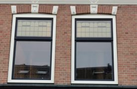 Een kunststof kozijn in een imitatie schuifraam. Gecombineerd met glas in lood om de oude originele stijl te benaderen