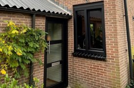 Kunststof kozijnen in zwarte uitvoering en moderne voordeur te Bilthoven