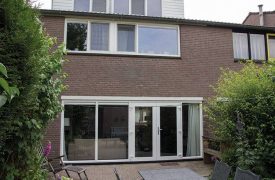 Kunststof kozijnen in de achtergevel woning maarssen met raamkozijnen op verdieping en openslaande deuren in woonkamer